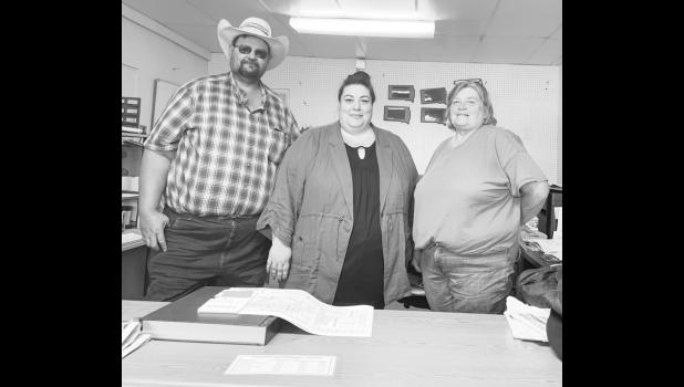 Business as usual ... during the ownership transition of The Bison Courier. New owners Russel and Krissy Johnson pictured with Bison team member Arlis Seim.